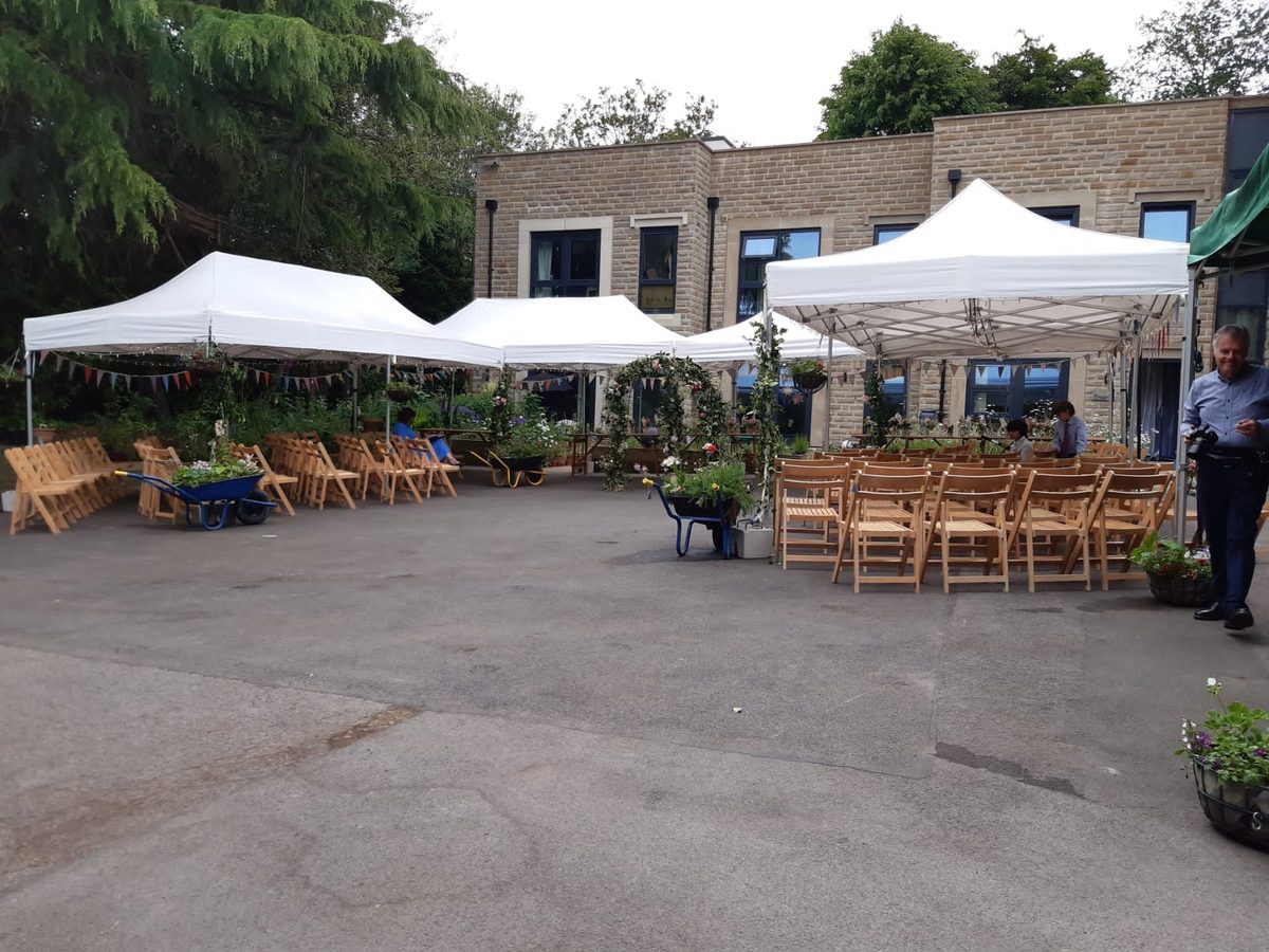 Pagoda marquees and rows of wooden chairs set up for a rustic wedding
